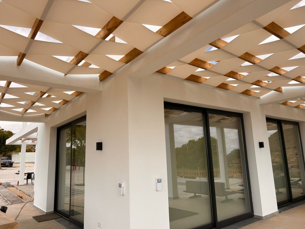 Pergola blanca con enrejado de madera, ideal para espacios al aire libre y jardines.